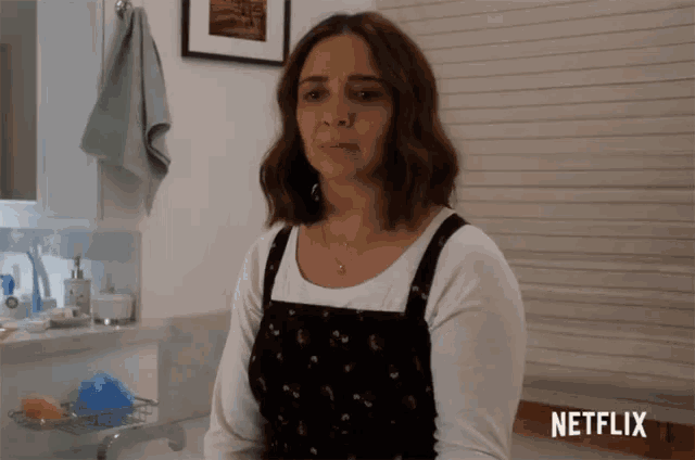 a woman is sitting in a bathroom with a netflix logo in the corner