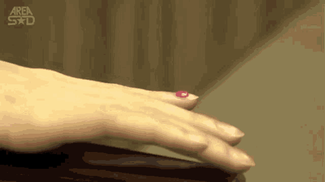a close up of a woman 's hand with a pink nail polish on it