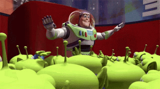buzz lightyear is surrounded by green aliens from toy story .