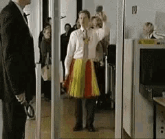 a man in a suit stands next to a woman in a colorful skirt