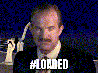 a man with a mustache is standing in front of a ship and the words #loaded are displayed above him