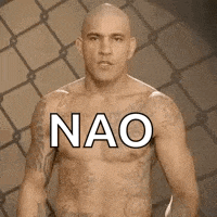 a bald man with tattoos on his chest is standing in front of a fence .