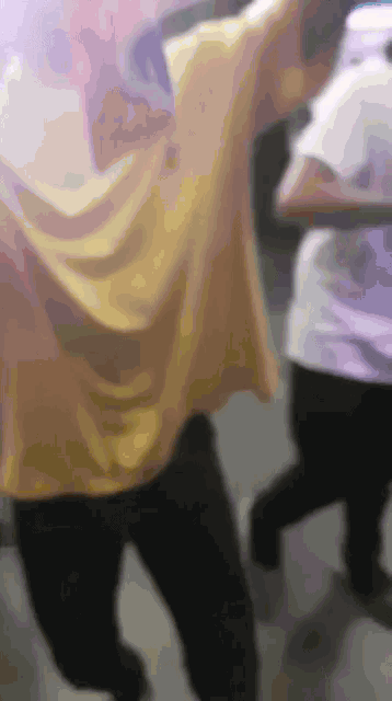 a blurry picture of a man in a yellow shirt dancing