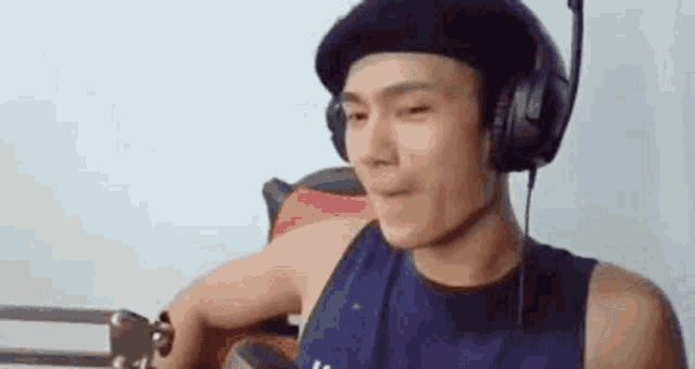a man wearing headphones and a hat is sitting in a chair .