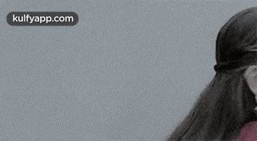a black and white photo of a smiling woman wearing earrings and a nose ring .