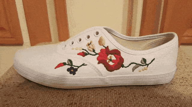 a white shoe with embroidered flowers on the side