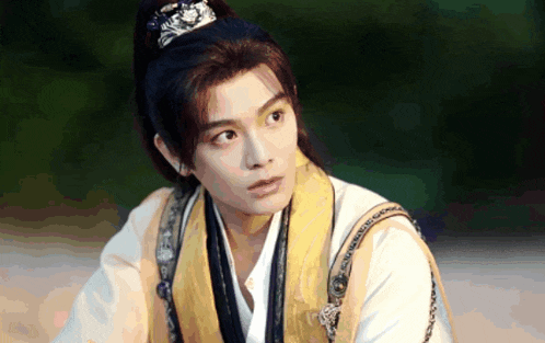 a young man with a ponytail is wearing a traditional costume