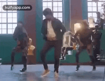 a man is dancing with a group of people in a room .