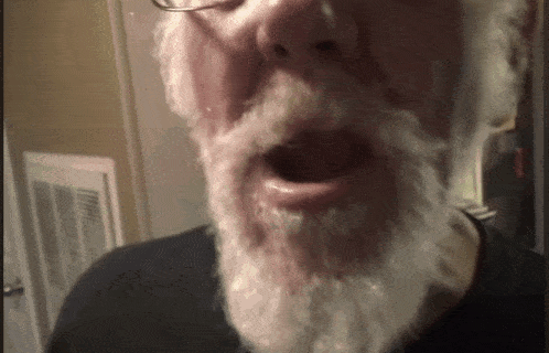 a man with a white beard and glasses is talking