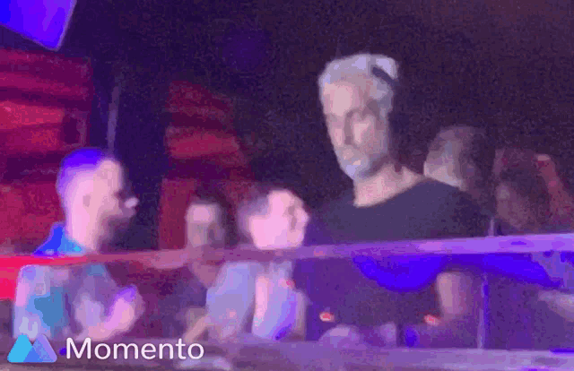a blurry picture of people in a club with the word momento on the bottom right
