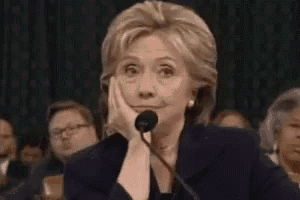 a woman is sitting in front of a microphone with her hand on her face .