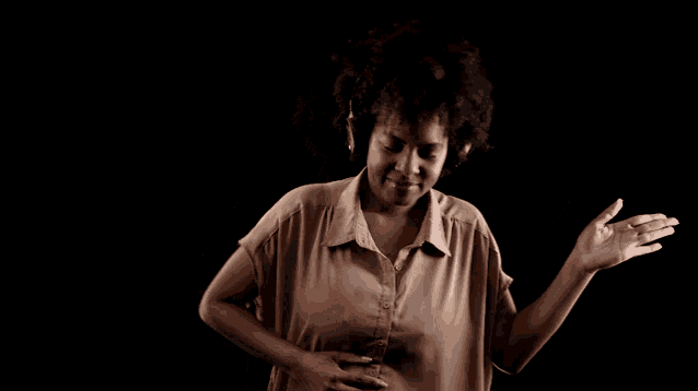 a woman wearing headphones is dancing and smiling
