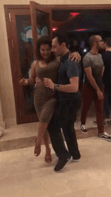 a man is holding a woman in his arms as they dance