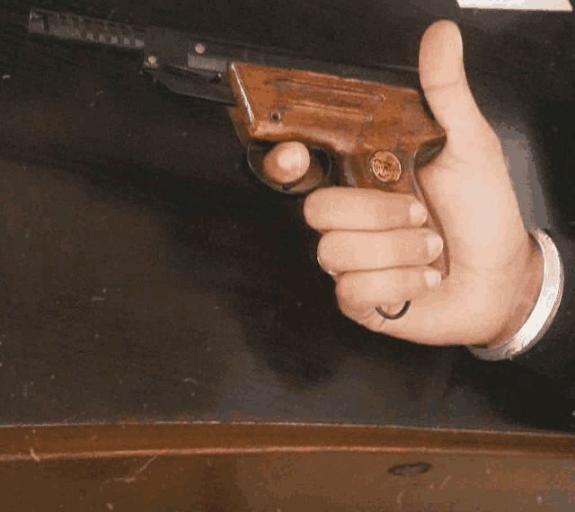 a person holding a gun with a gold coin on the handle