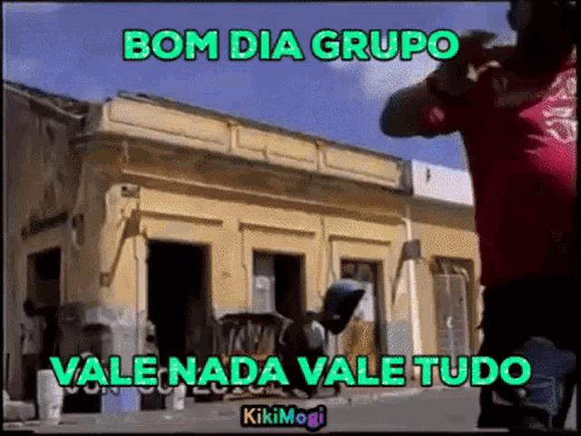 a man in a red shirt is standing in front of a building with the words bom dia grupo vale nada vale tudo