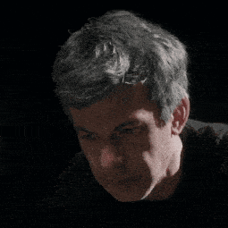 a close up of a man 's face in a dark room