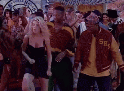 a group of people are dancing at a party and one of them is wearing a jacket with the letter s on it