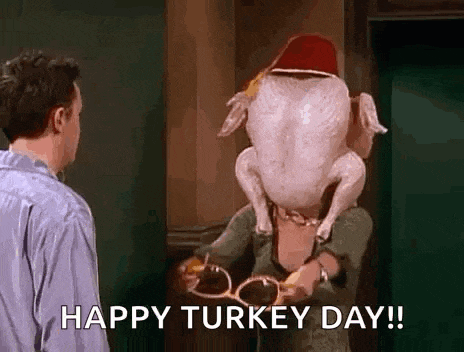 a man is standing next to a woman holding a turkey with a hat on her head .