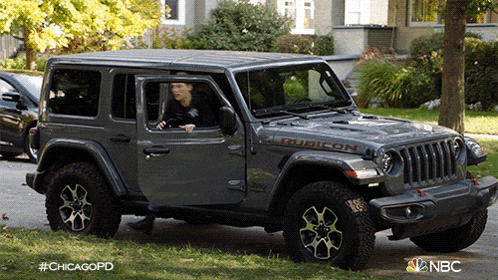 a man is driving a jeep with the word rubicon on the hood