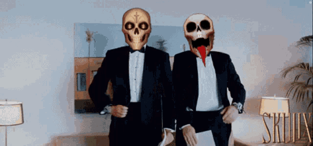 two men in tuxedos with skulls on their faces standing next to each other
