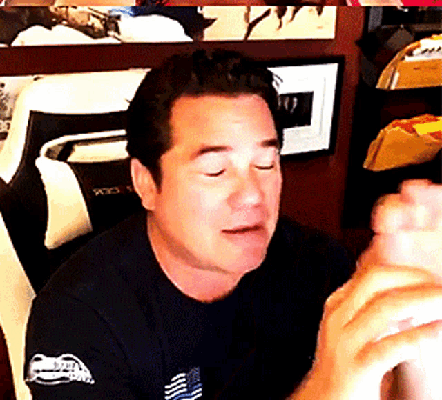 a man wearing a black t-shirt with a sticker on the sleeve that says ' a ' on it