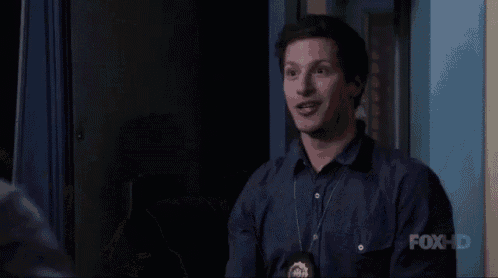 a man wearing a police badge is making a funny face while talking to another man .