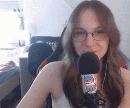 a woman is wearing glasses and holding a microphone with a cat sticker on it .