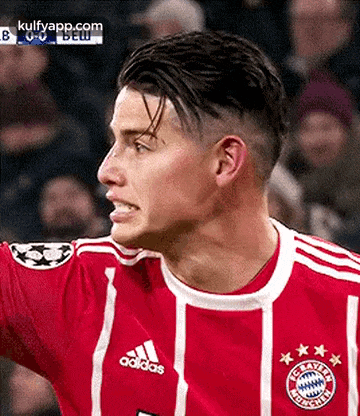 a close up of a soccer player wearing a red and white adidas jersey .