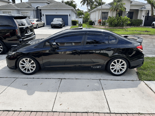 a black car is parked in front of a house with a sticker on the side that says vtec