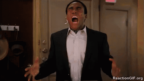 a man in a suit and tie is screaming with his mouth open in front of a door .