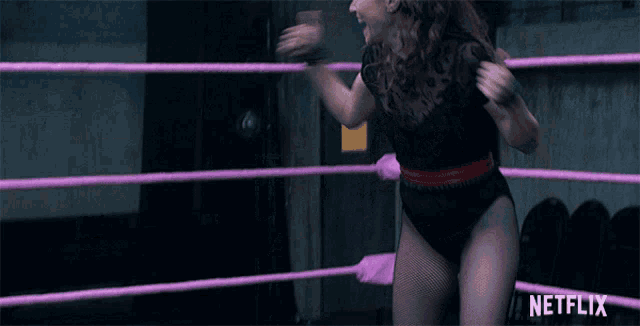 a woman is in a wrestling ring with a netflix logo in the background