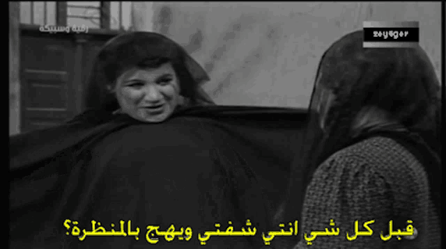 a black and white photo of two women with arabic writing on them
