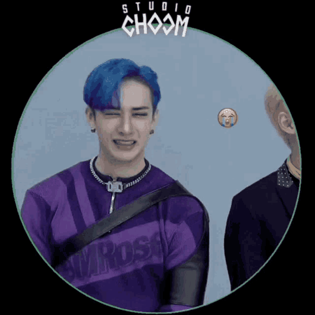 a man with blue hair is wearing a purple shirt that says wrosey