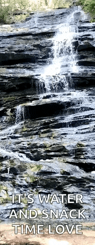 a waterfall is surrounded by rocks with a caption that says it 's water and snack time love .