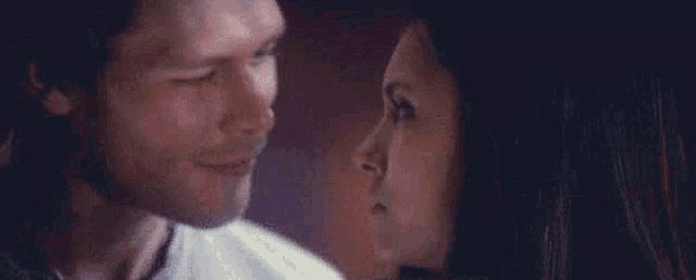 a man and a woman are looking at each other .