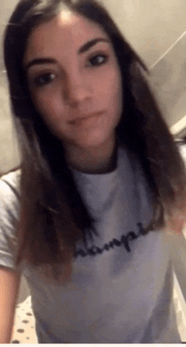 a woman is wearing a champion shirt and taking a selfie