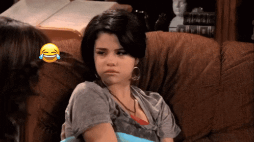 a woman sits on a couch with a laughing emoji on the corner