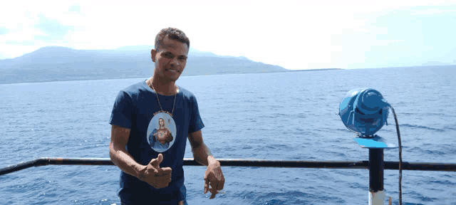 a man wearing a shirt with a picture of jesus on it giving a thumbs up