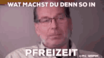 a man wearing glasses is sitting in front of a wall with the words wat machst du denn so in pfreizeit