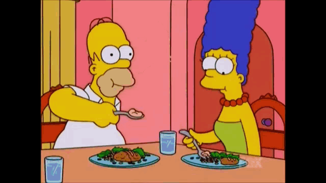 homer simpson and marge simpson sitting at a table with plates of food