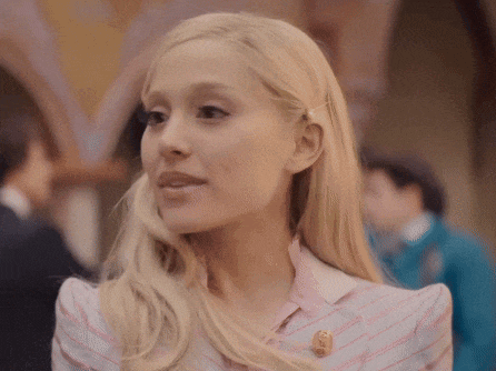 a woman with blonde hair wearing a pink and white striped shirt