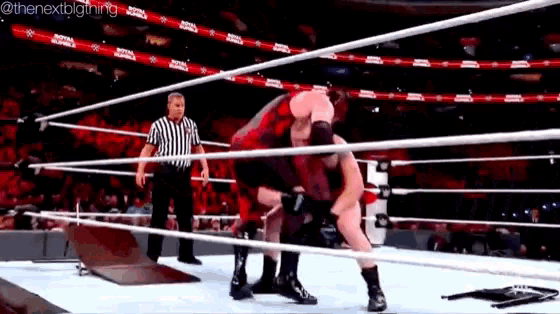 two men are wrestling in a wrestling ring while a referee watches .