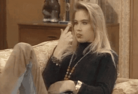 a woman is sitting on a couch making a funny face .
