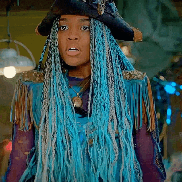 a girl with blue braids is wearing a pirate hat .
