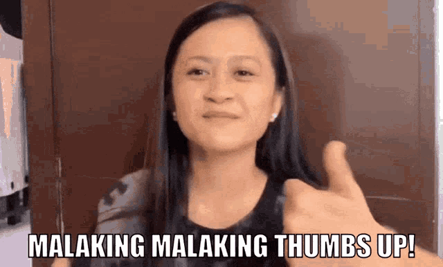 a woman giving a thumbs up with the words malaking malaking thumbs up