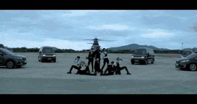 a group of people are posing for a picture in front of a helicopter on a runway .