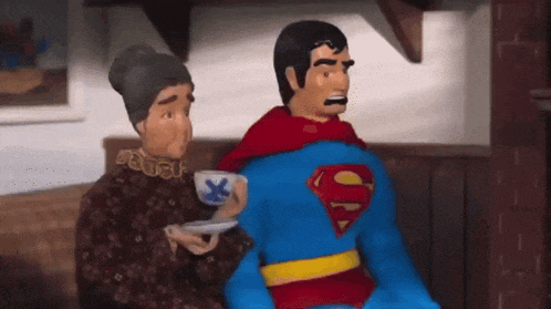 a man in a superman costume sits next to an older woman
