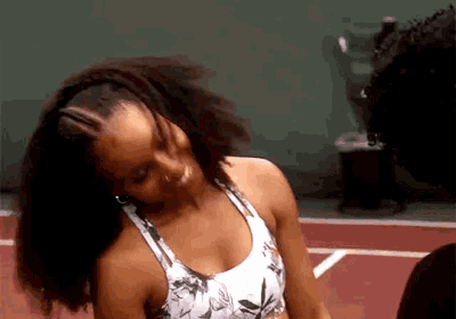 a woman is standing on a tennis court wearing a sports bra .