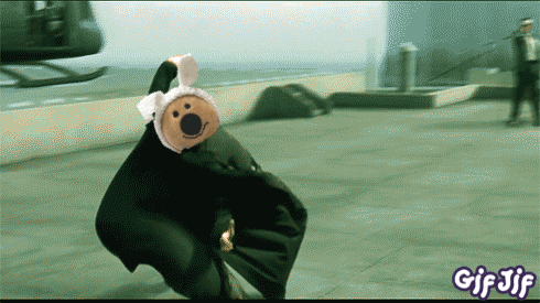 a gif of a teddy bear in a black suit with a bunny hat on