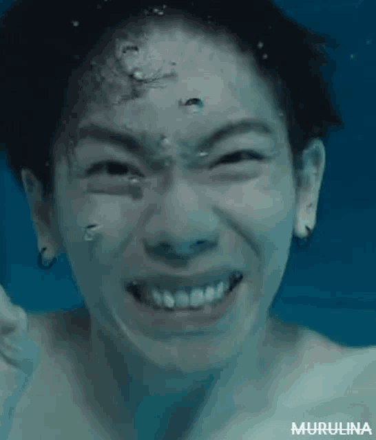 a close up of a person making a funny face under water .